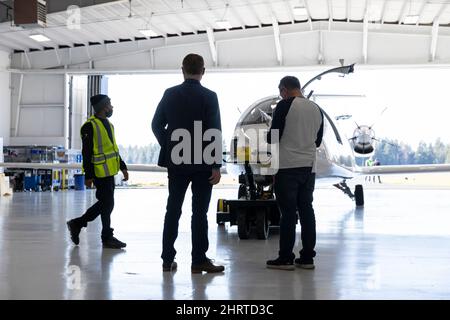 Arlington, Washington, Stati Uniti. 25th Febbraio, 2022. Greg Davis (centro), CEO ad interim di Eviation, osserva che i membri dell'equipaggio di terra preparano il prototipo di aeromobile elettrico di Alice per un test in taxi presso la sede di Eviation nell'aeroporto municipale di Arlington. Eviation prevede di effettuare il primo volo di Alice nelle prossime settimane in attesa di ulteriori preparativi per i test di volo e taxi. Credit: Paul Christian Gordon/Alamy Live News Foto Stock