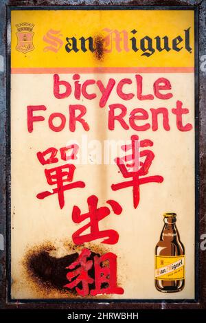 Un menu a bordo di birra riproposto come cartello bilingue cinese e inglese per il noleggio di biciclette sull'Outlying Island di Cheung Chau, Hong Kong Foto Stock