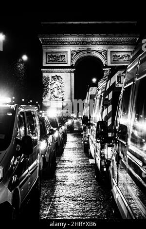 Foto in scala di grigi di automobili bloccate nel traffico vicino all'Arco di Trionfo Foto Stock