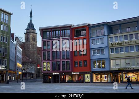 Stoccarda, Germania - 06 gennaio 2022: Facciate colorate di edifici residenziali e commerciali. Donna in inverno vestiti camminare attraverso vuoto Foto Stock