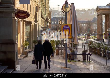 Stoccarda, Germania - 06 gennaio 2022: Coppia anziana che cammina insieme attraverso la città. Anziani in nero abbigliamento vetrine shopping. Vista posteriore. Foto Stock