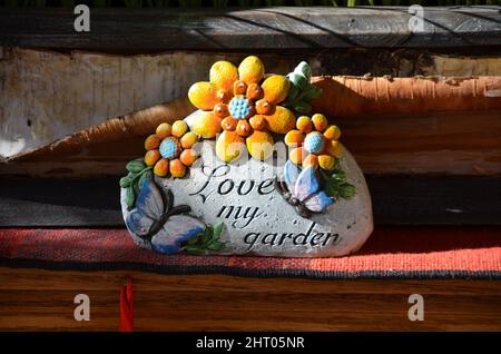 Primo piano di una figurina con fiori, farfalle e un testo 'Love my Garden' Foto Stock