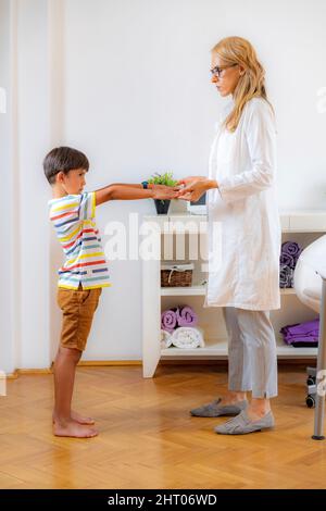 Ragazzo sottoposto ad esame medico fisico con terapista Foto Stock