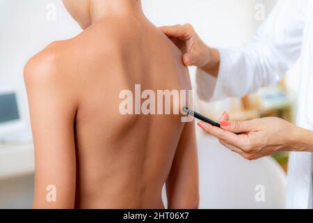 Medico pediatrico che esamina la postura di un ragazzo Foto Stock