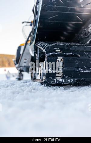 La parte posteriore della motoslitta in inverno. Cavalcare nella neve su una motoslitta. Sospensione posteriore di una motoslitta.motoslitta in condizioni invernali. Pelle estrema Foto Stock