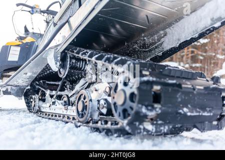 La parte posteriore della motoslitta in inverno. Cavalcare nella neve su una motoslitta. Sospensione posteriore di una motoslitta.motoslitta in condizioni invernali. Pelle estrema Foto Stock