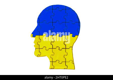Silhouette della testa di un uomo in pezzi di puzzle di legno dipinte dai colori nazionali dell'Ucraina isolato su bianco. Foto Stock
