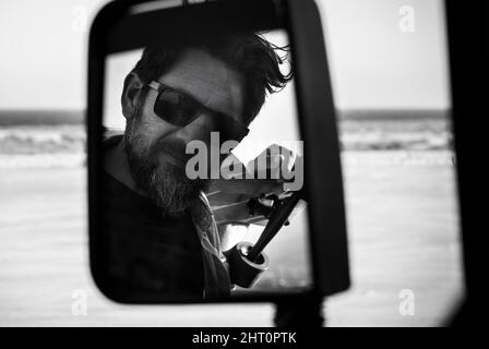 Bel ritratto uomo in bianco e nero nello specchio per auto. Concetto di stile di vita di avventura e di stile di barba di moda persone. Modello adulto maturo con su Foto Stock