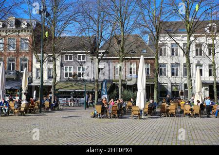 Roermond, Paesi Bassi - Febbraio 9. 2022: Vista sulla piazza con caffè all'aperto, persone seduti all'esterno, vecchi edifici tipici sfondo Foto Stock