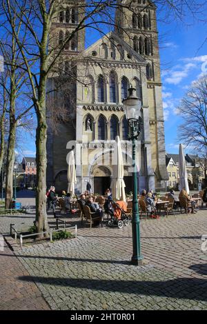 Roermond, Paesi Bassi - Febbraio 9. 2022: Vista sulla piazza con caffè esterno, vecchia chiesa medievale nella soleggiata giornata invernale Foto Stock