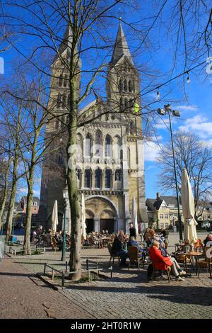 Roermond, Paesi Bassi - Febbraio 9. 2022: Vista sulla piazza con caffè esterno, vecchia chiesa medievale nella soleggiata giornata invernale Foto Stock