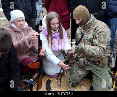 Non esclusiva: KHARKIV, UCRAINA - 19 FEBBRAIO 2022 - Un ufficiale di polizia insegna alle donne come maneggiare le armi da fuoco durante la trivella di difesa territoriale per c Foto Stock