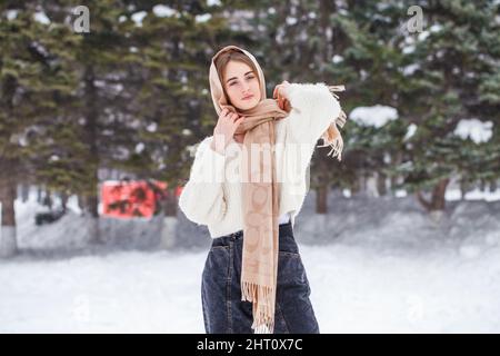 ritratto di giovane bella ragazza in posa nel parco invernale Foto Stock
