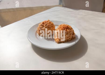 Insalata di polpo, in forma di palla servita su un piatto. Concetto di cucina spagnola. Foto Stock