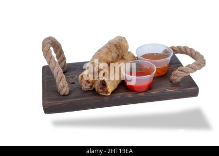 pancake su un supporto di legno con vasetti di salsa calda. NEM, rotoli di carta per riso vietnamita Foto Stock