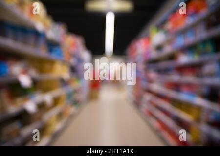Immagine sfocata astratta dello sfondo del supermercato. Scaffali defocused con prodotti. Conservare. Settore retail. Rack. Sconto. Concetto di inflazione e crisi. Foto Stock