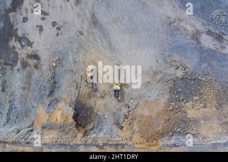 Vista aerea in una cava, escavatore e dumper durante il carico di roccia minata. Foto Stock