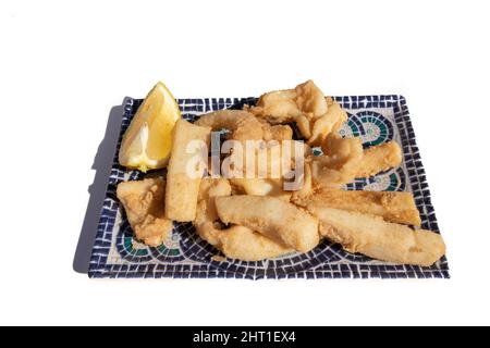 Strisce di seppie fritte, chiamate Chocos Fritos in spagnolo. Servito su un piatto rettangolare decorativo. Cucina spagnola. Foto Stock