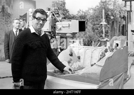 Programmi televisivi 'Square World': Michael Bentine visto qui sul set del programma televisivo Square World. I membri del team BBC Special Effects si accovacciano sotto una parte del set pronto a creare una piccola serie di esplosioni. 1965 A1079 Foto Stock