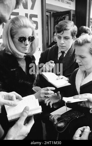 Prove prima della Royal Film Performance for Born Free, presso l'Odeon, Leicester Square, Londra, domenica 13th marzo 1966. La nostra foto mostra... Catherine Deneuve firma autografi fuori teatro. Foto Stock
