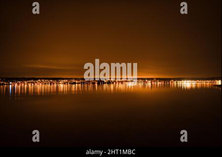 Scena ipnotizzante vista notturna del Lago di Costanza con lunga esposizione, luci e riflessi Foto Stock