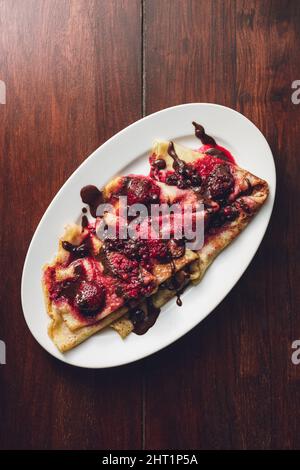 Closeup verticale delle frittelle con frutti di bosco e cioccolato. Foto Stock