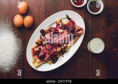 Primo piano delle frittelle con frutta di bosco e cioccolato. Foto Stock