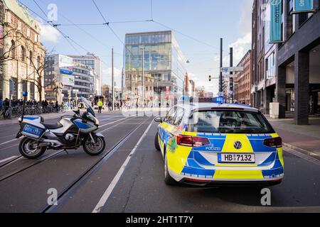 Brema, Germania. 26th Feb 2022. Mentre i membri della scena di sinistra dimostrano nel centro della città l'apertura dei confini europei, gli agenti di polizia bloccano una strada con una moto e una macchina di polizia. Credit: Mohssen Assanimoghaddam/dpa/Alamy Live News Foto Stock