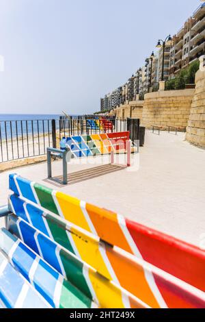 Foto verticale delle panchine colorate sulla strada. Foto Stock