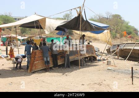 Gruppo di persone indiane che fanno una barca di legno fatta a mano a Bharuch, India Foto Stock