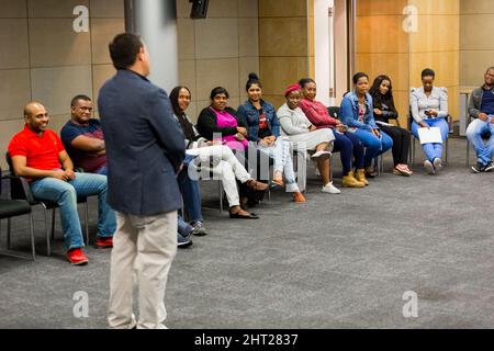 Educatore che istruisce diversi studenti adulti sulla finanza personale Foto Stock