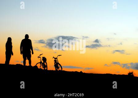 coppia al tramonto con bici paesaggio Foto Stock