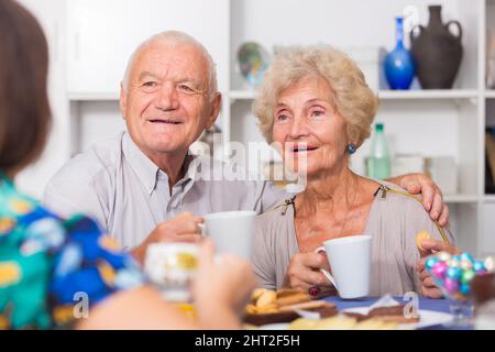 Coppia anziana felice godendo la conversazione con la femmina Foto Stock