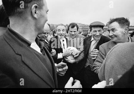 Il tradizionale Royal Shrovetide Football Match, una partita di "calcio medievale" giocata ogni anno il martedì di Shrove e il mercoledì delle ceneri nella città di Ashbourne nel Derbyshire. Ospite d'onore Sir Stanley Matthews è affollato dalla folla da alcuni abitanti del villaggio fino al punto di partenza del gioco. 22nd febbraio 1966. Foto Stock