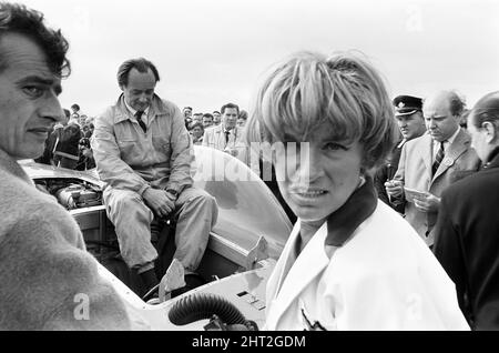 Proteus Bluebird, la vettura in cui Donald Campbell ha rotto il World Automobile Speed Record ha ora fatto la sua ultima corsa, a 5 mph, alla RAF Station, Debden, Essex, 19th giugno 1966. Campbell doveva dare una dimostrazione di corsa ad un gala là, Ma 5 giorni prima, la macchina è stata gravemente danneggiata quando, con il pilota di corsa Peter Bolton ai comandi, ha battuto attraverso una recinzione di legno e siepe a 100 mph, ha navigato 10ft in aria attraverso la Cambridge Chelsford strada, e infine ha fatto girare attraverso un campo per 200 metri. Anche in foto, moglie Tonia Campbell. Foto Stock