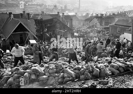 I soccorritori che baggono e spostano parte della spolietta di carbone a seguito del catastrofico crollo di una punta di spolietta collassata nel villaggio gallese di Aberfan, vicino a Merthyr Tydfil, il 21 ottobre 1966. La frana risultante di 40.000 metri cubici di liquame di carbone ha inghiottito il villaggio e Pantglas Junior School uccidendo 116 bambini e 28 adulti. È stato causato da un accumulo di acqua nella roccia e scisto sulla punta locale dello spolio collirio, che improvvisamente ha iniziato a scivolare in discesa sotto forma di slurry.The eventi di Venerdì, 21 ottobre 1966 Tip no 7, che era 500 piedi sopra il villaggio di Aberfan, vicino a Merth Foto Stock