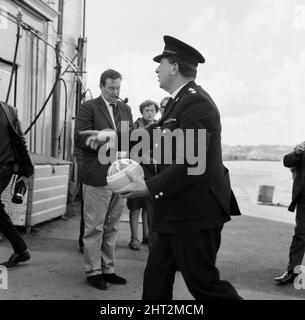 Un Ispettore capo della polizia che porta una palla per bambini che è stato trovato durante la ricerca della barca da diporto mancante Darlwyne. Il Darlwyne affondò il 31st luglio 1966, il che portò alla perdita di 31 vite e il relitto della barca non fu mai trovato. I corpi di solo 12 delle 31 persone a bordo sono stati recuperati. 4th agosto 1966. Foto Stock