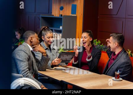 Gruppo di gente di busniess multirazziale stanno ridendo mentre si siede Foto Stock