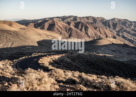 Curving Road e Long Shadows sulla strada fino a Dantes View nel Death Valley National Park Foto Stock