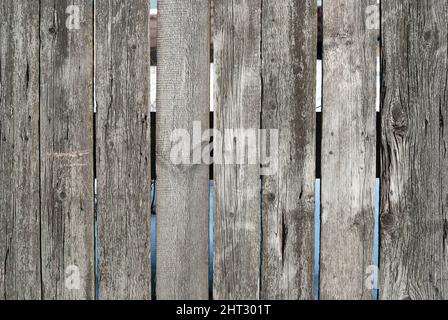 Lo sfondo è fatto di vecchi assi di legno (travi di legno). Texture vintage, sfondo. Grigio sbiadito Foto Stock