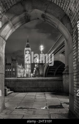 Verticale, in scala di grigi, la torre dell'orologio Big ben da un arco, Londra, Regno Unito Foto Stock