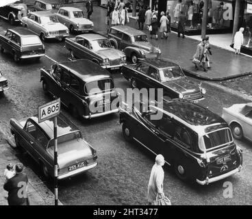 Taxi in una strada di Glasgow, bloccato nel traffico intorno al centro della città. Agosto 1965. Foto Stock