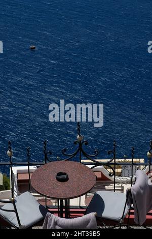 La vista è fantastica dalla terrazza di un ristorante con un tavolo e sedie sul Mar Egeo di Santorini Foto Stock