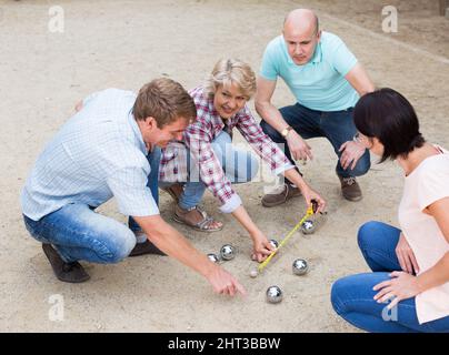 Allegri maschi e femmine che giocano a petanque Foto Stock