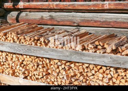 tronchi impilati di fronte a casa di legno Foto Stock
