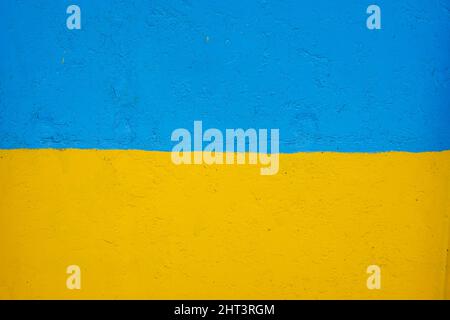 Muro di cemento dipinto in giallo e blu come bandiera Ucraina, il paese di vittima dell'aggressore Foto Stock