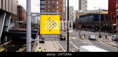 Metro link tram stazione segno e centro città attraversare le strade e segnali di traffico dietro Manchester UK Foto Stock