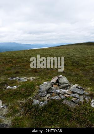Un cairn su Leachann Mheaddhonach, che domina i Monti Grampian, tra cui Glen Lyon, e Glen Coe in lontananza, su Loch Rannoch e Rannoch Foto Stock