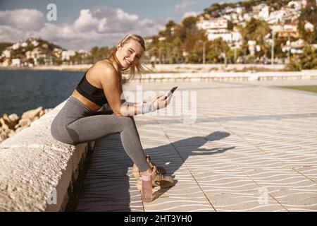 Bella donna che posa sul lungomare dal mare Foto Stock