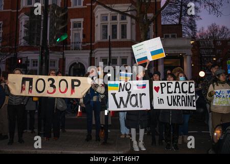 Londra, Inghilterra, Regno Unito 26 febbraio 2022 centinaia di persone si riuniscono fuori dall’Ambasciata russa in solidarietà con l’Ucraina per protestare contro l’invasione del paese da parte della Russia. I manifestanti scrivono messaggi sul muro dell'ambasciata e lasciano segni attaccati alle porte e alle ringhiere Foto Stock